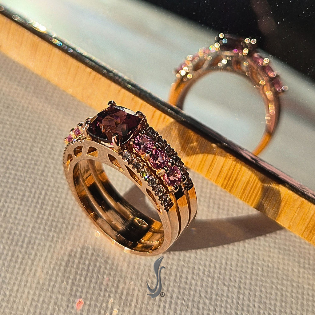 Anello con granato royal, zaffiri rosa e diamanti in oro rosa – luce calda e riflessi preziosi su design artigianale italiano