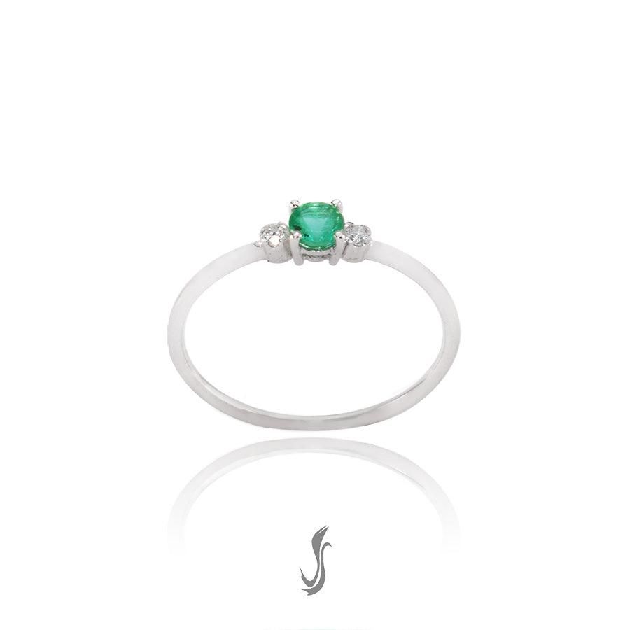 anello in oro bianco con diamanti e uno smeraldo taglio brillante
