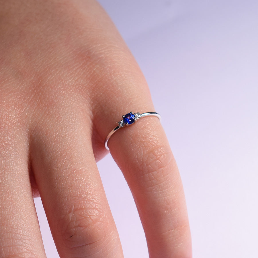 anello sottile in oro bianco con diamanti e uno zaffiro taglio brillante